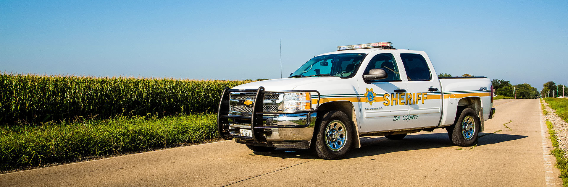 Ida County Sheriff truck sitting in the middle of the highway with cornfields in the background